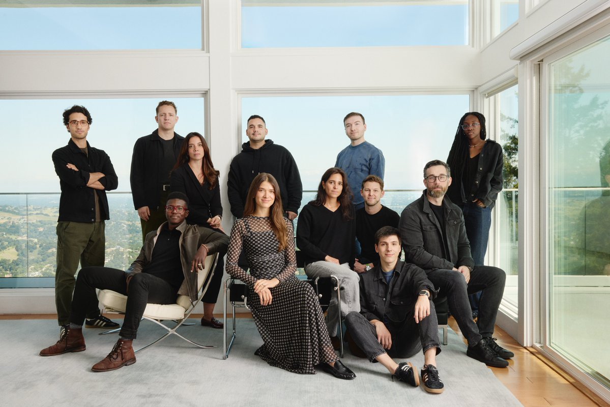 Team portrait of the TasteLabs company in a glass room overlooking hills